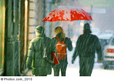 A group of three walk in “weather bomb”-like weather.  © Photos.com 2010