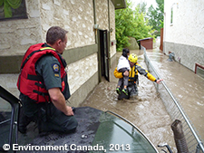 Image 1b. Rescue workers helping child from flooded home.
